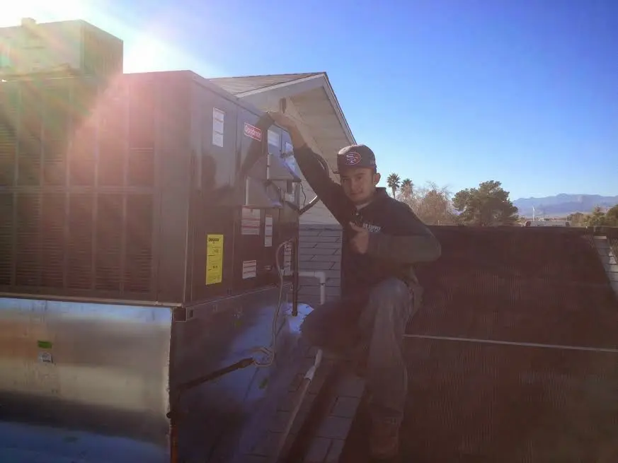HVAC technician performing AC Tune-Up on a rooftop unit in Lincolnshire