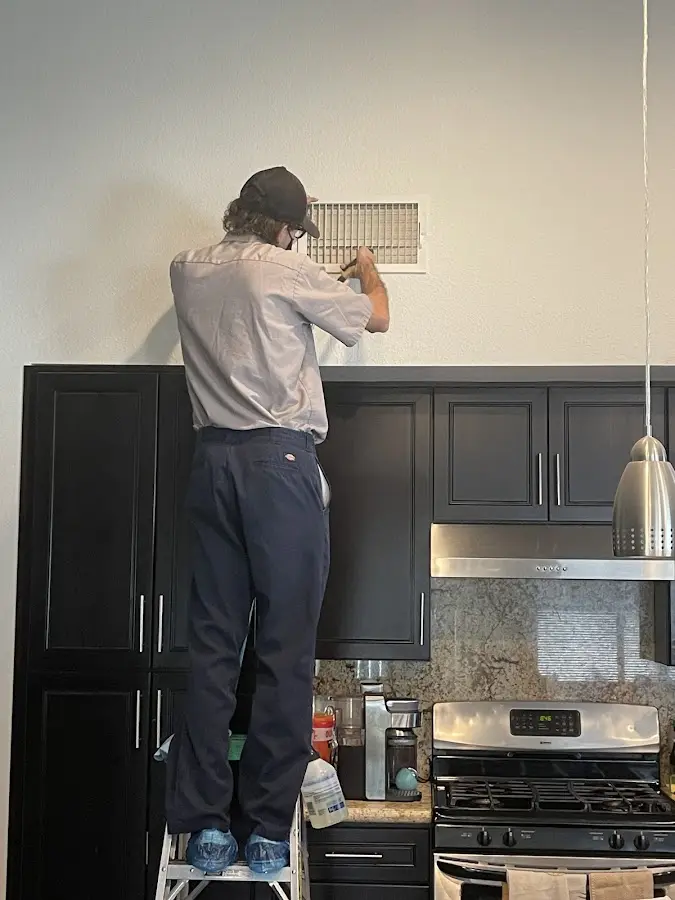 Technician inspecting an air vent during HVAC service in Lincolnshire